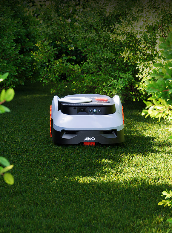 Der Segway Navimow i105E Mähroboter mäht einen grünen Gartenrasen.