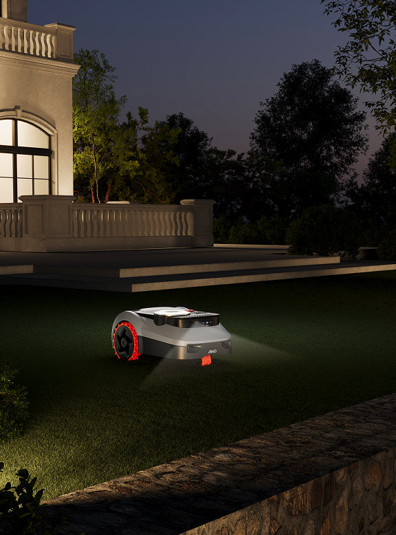 Navimow i105E Mähroboter mäht nachts den Rasen vor dem Haus.