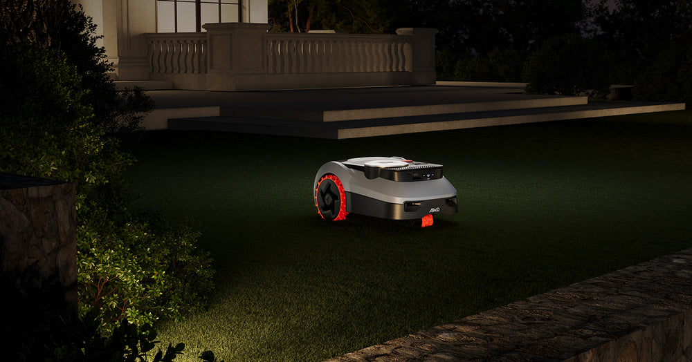 Ein Segway Navimow i105E Mähroboter mäht nachts auf grünem Rasen.